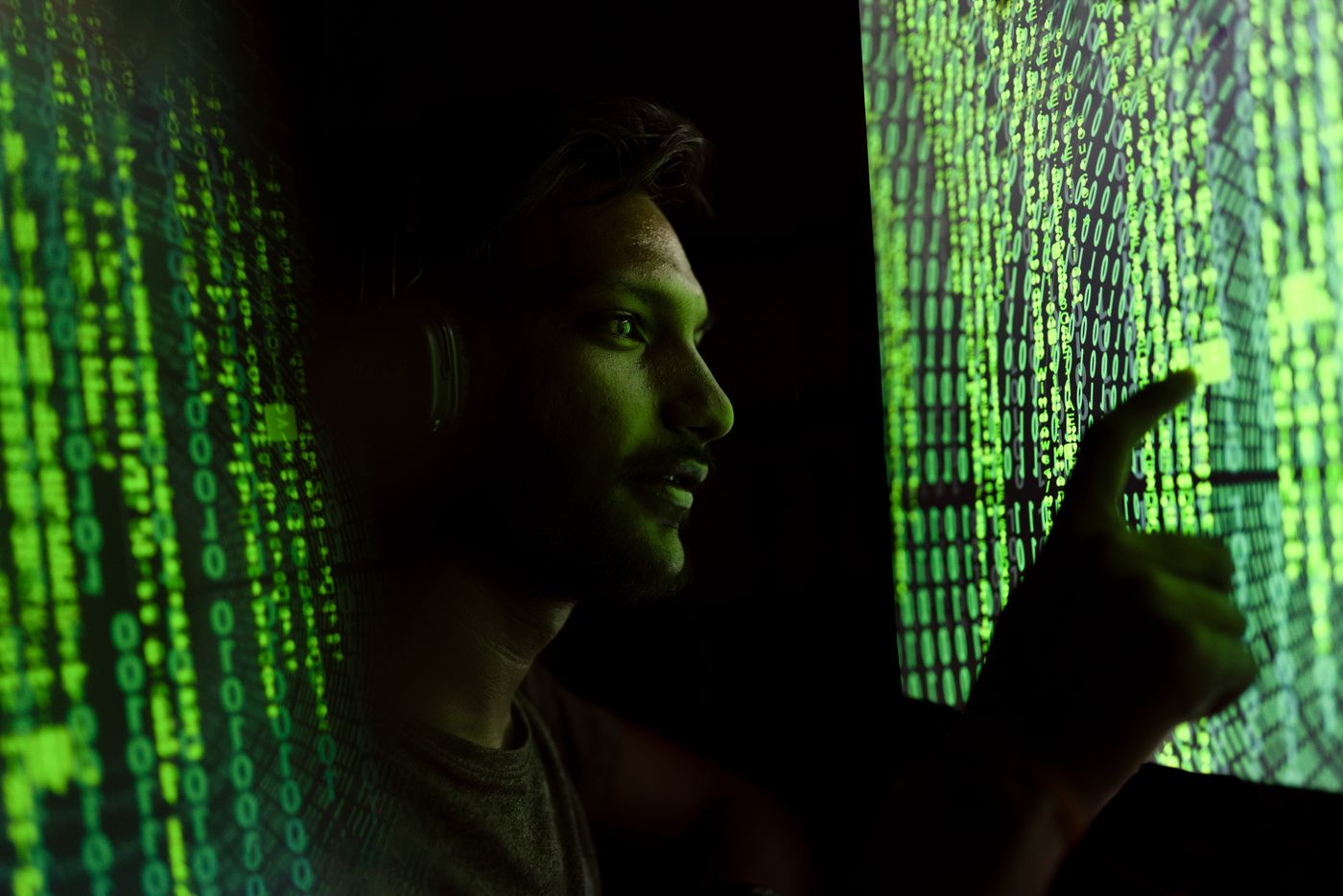 Person analyzing streams of code projected on screens