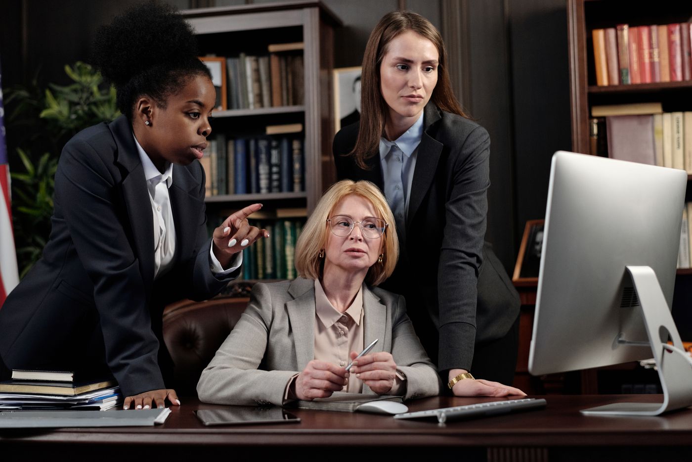 Legal professionals reviewing case information together at a computer in a law office